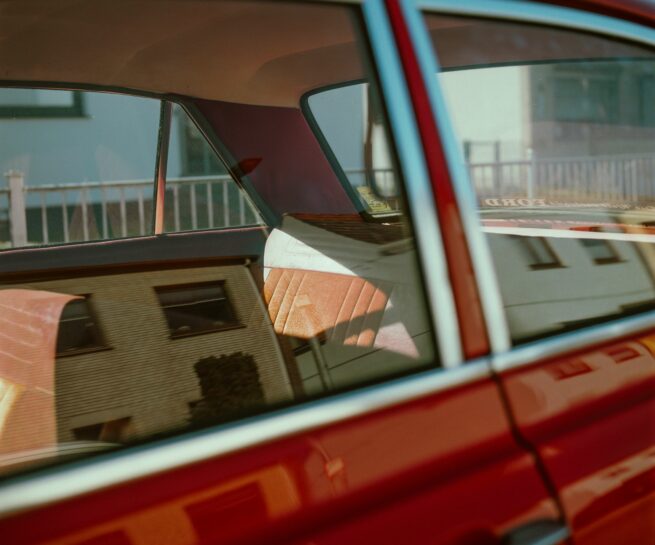 detail van een rode auto waarop de achterbank te zien is