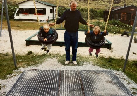 Familiefoto: vader met twee kinderen op de schommel